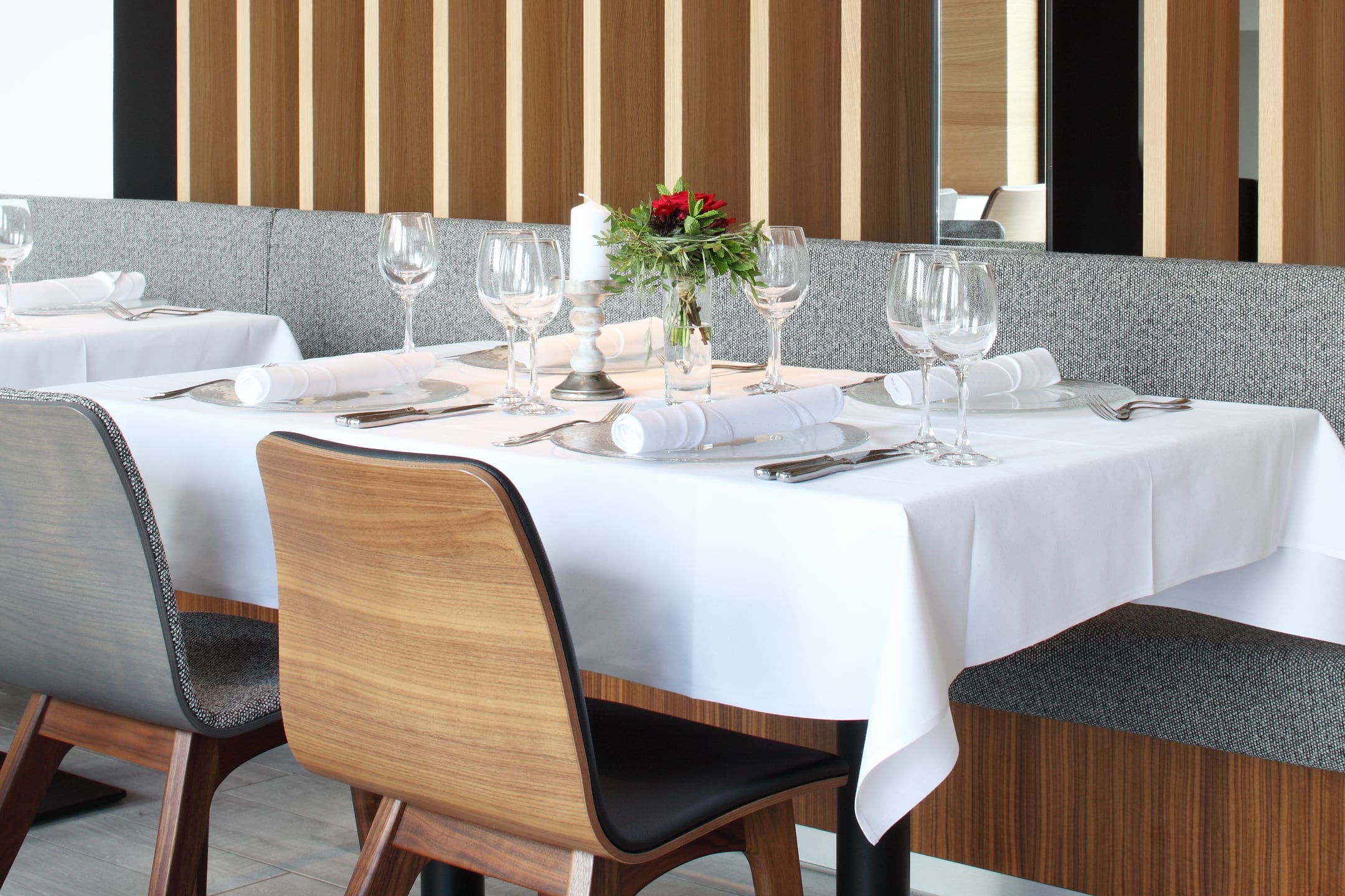 Festlich eingedeckter Tisch mit weißen Tischdecken und Weingläsern